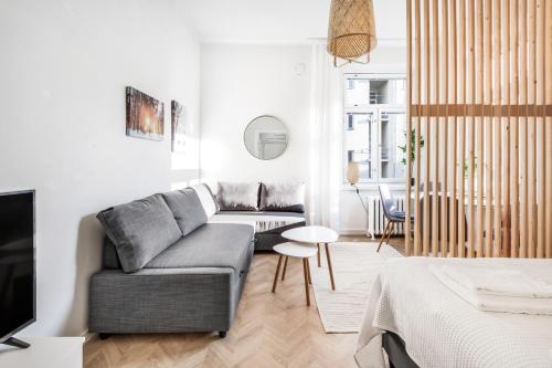a living room with a couch and a tv at WeHost Nordic Glamour nearby the Tervasaari Island in Helsinki