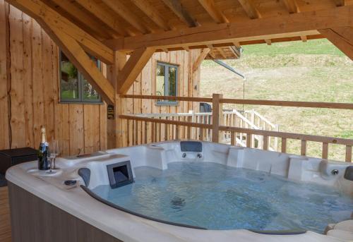 a large hot tub in a wooden house at Luxury Chalet, stunning views with hot tub & sauna in La Côte dʼArbroz