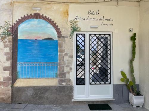 una pared con una puerta y una pintura del océano en Antica dimora del mare - Luxury suite, en Diamante
