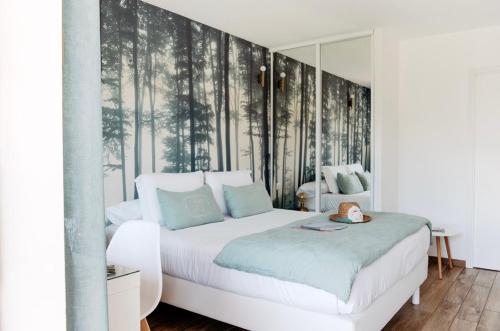 a bedroom with a white bed and a large window at La Cabane du Ferret in Lège-Cap-Ferret