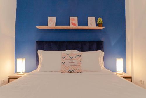 een slaapkamer met een blauwe muur en een bed met 2 lampen bij Le Majorelle de Carthage in Le Kram