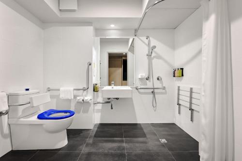 a white bathroom with a toilet and a sink at Holiday Inn Perth City Centre by IHG in Perth