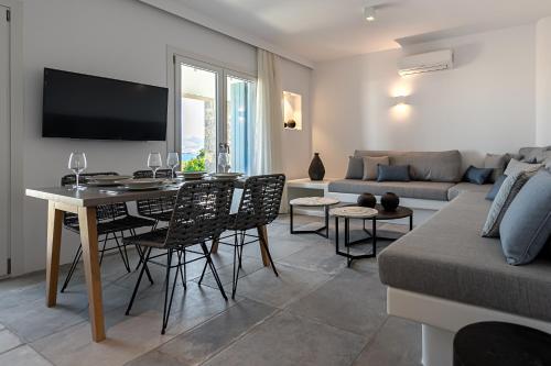 a living room with a table and chairs and a couch at Manesis Suites in Pollonia