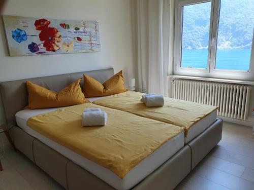 un grande letto in una stanza con due finestre di Villa Violetta - Bellavista a Castagnola