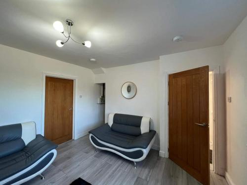 a living room with two couches and a door at Cosy, Modern Home Near BHX, NEC and City Centre in Birmingham
