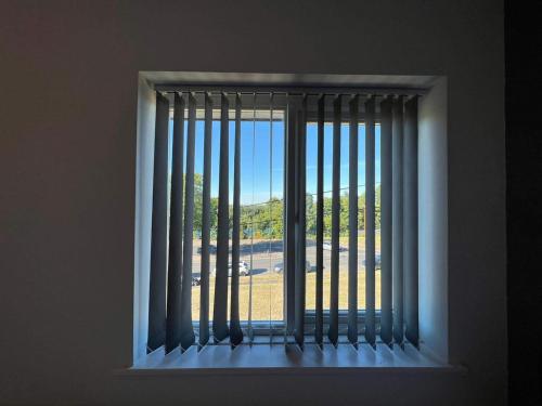 a window with vertical blinds and a view of a field at Cosy, Modern Home Near BHX, NEC and City Centre in Birmingham