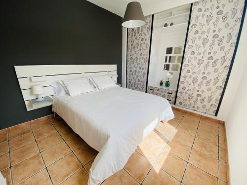 sypialnia z białym łóżkiem i podłogą wyłożoną kafelkami w obiekcie Apartamento Niar w mieście Playa Honda
