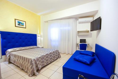 una camera con un letto blu e un divano blu di Hotel Haus Charlotte a San Benedetto del Tronto