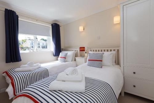 a bedroom with two beds with towels on them at Atlantic Blue in Carbis Bay