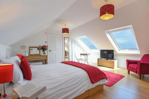 a bedroom with a bed and a desk and a tv at St Ives Bay View in Carbis Bay
