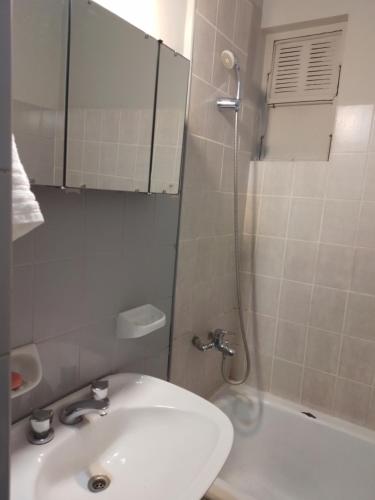 y baño blanco con lavabo y ducha. en Feliz Estadia en Mendoza