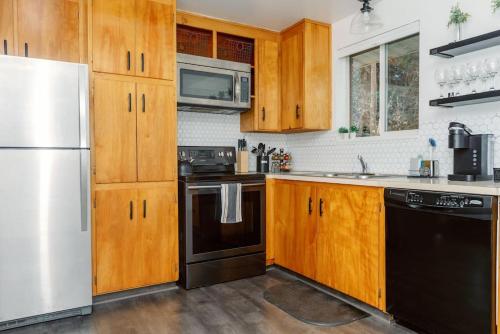 a kitchen with wooden cabinets and a white refrigerator at Cheerful 3 Bedroom near USU - Inspiring Memories in Logan