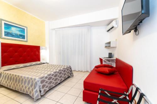 a bedroom with a red bed and a red chair at Hotel Haus Charlotte in San Benedetto del Tronto