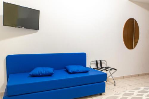 a blue couch with two blue pillows in a room at Hotel Haus Charlotte in San Benedetto del Tronto