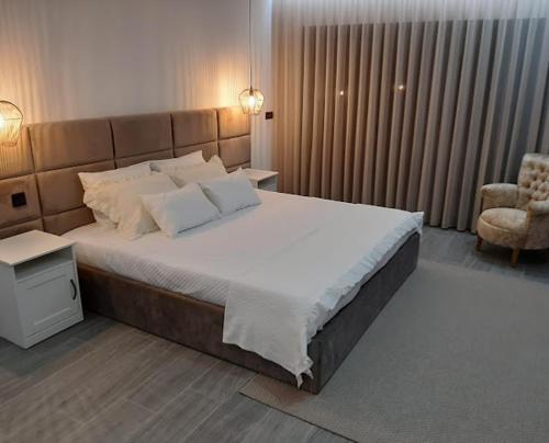 a bedroom with a large bed and a chair at CRASTO PAYVA DOURO NATURE in Castelo de Paiva