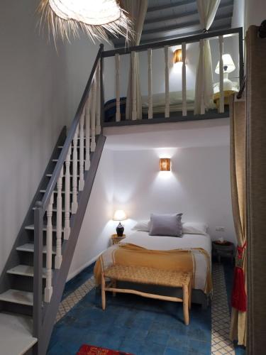 a bedroom with a bed and a staircase at RIAD MAROSKO in Essaouira