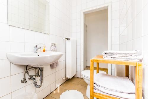 Un baño blanco con lavabo e inodoro. en Apartment Köln Weidenpesch, en Colonia