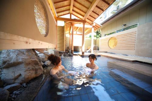 two children playing in the water in a swimming pool at Biwako Ryokusuitei in Otsu