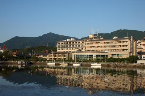 a large building with boats in a body of water at Biwako Ryokusuitei in Otsu