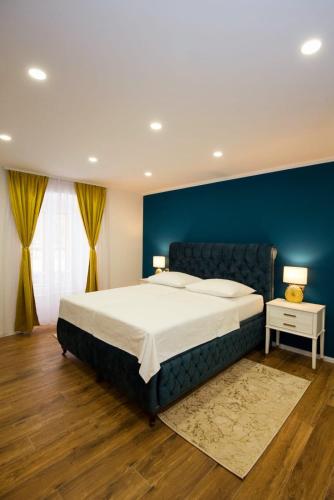 a bedroom with a large bed with a blue wall at Gold Luxury Room in Split