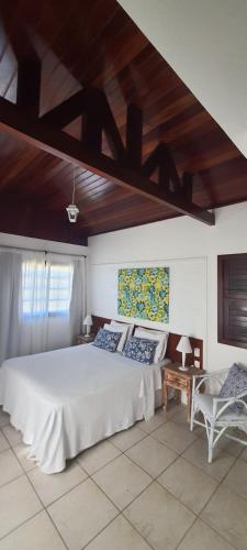 um quarto com uma cama branca e um tecto de madeira em Hotel Tibau Lagoa em Pipa