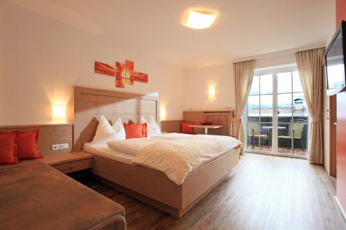 a hotel room with a bed and a large window at Hotel Garni Ingeborg in Westendorf
