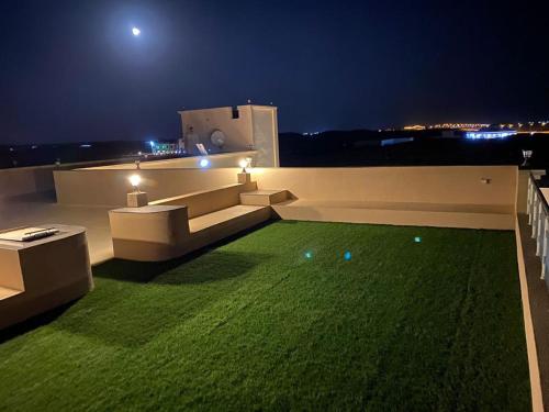 um relvado verde no telhado de uma casa à noite em Almouj Chalet em Salalah