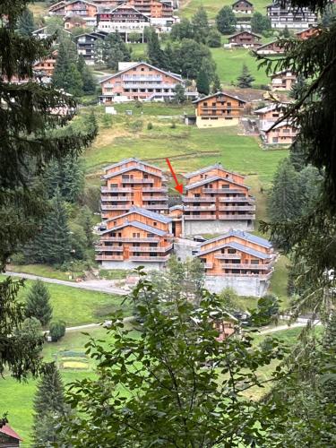 a group of buildings on a hill with trees at Châtel - Appartement 4-6 personnes - Les Châlets des Freinets C203 in Châtel