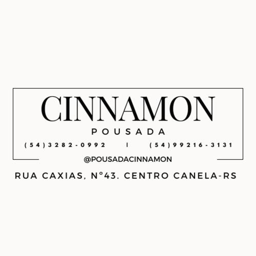 un signe qui dit cinemon sur fond blanc dans l'établissement Pousada Cinnamon, à Canela