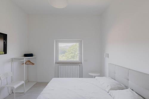Claudio casa di Alba في سان سيساريو: غرفة نوم بيضاء بها سرير ونافذة