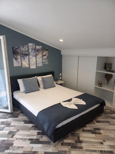 a bedroom with a large bed with blue walls at V&L Sunset in Ioannina