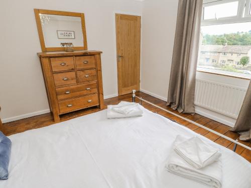 a bedroom with a bed and a dresser and a window at Rose Cottage in Barnard Castle