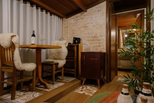 a dining room with a table and two chairs at Chalés Requinte da Mantiqueira in Monte Verde