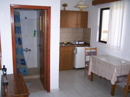 a kitchen with a table and a sink and a kitchen with a table at Evi Apartments And Studios in Theologos