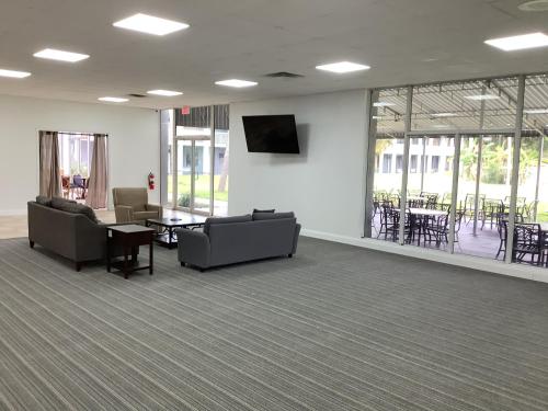 a waiting room with couches and a table and chairs at Heritage Park Inn in Kissimmee