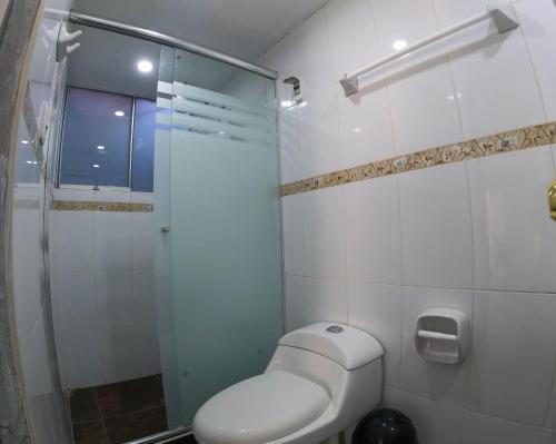a bathroom with a toilet and a glass shower at Hospedaje Bellido in Ayacucho