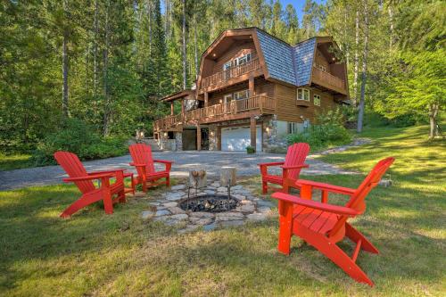 a group of red chairs in front of a log cabin at Wild Huckleberry Alpine Cabin Fireplace and Deck! in Alpine
