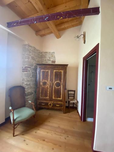a living room with a chair and a cabinet at LOCAZIONE TURISTICA IL BRICCHETTO in Parodi Ligure