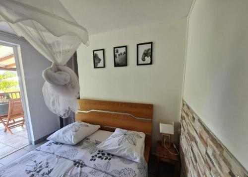 1 dormitorio con cama con dosel y ventana en A l'ombre du goyavier en Le François