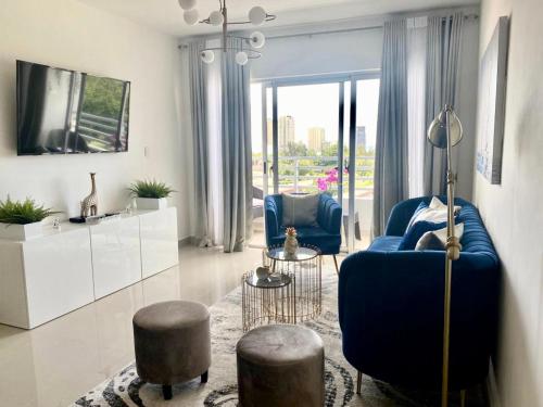 uma sala de estar com um sofá azul e duas cadeiras em Super Luxurious L6 Sky Blue Apartment em Santo Domingo