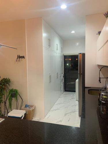 a kitchen with white cabinets and a tile floor at HERMOSO DEPARTAMENTO A UNOS PASOS DE LA PLAYA in Mazatlán