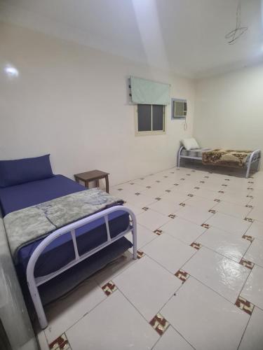 a bedroom with two beds and a tiled floor at شقة عائلية -ليست فندقية- 8 دقائق بالسيارة للحرم أو قباء - in Al Madinah