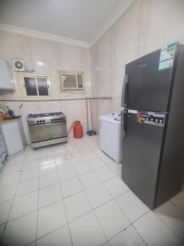 a kitchen with a refrigerator and a stove at شقة عائلية -ليست فندقية- 8 دقائق بالسيارة للحرم أو قباء - in Al Madinah