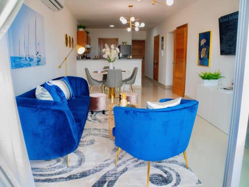 sala de estar con sillas azules y mesa en Super Luxurious L6 Sky Blue Apartment, en Santo Domingo
