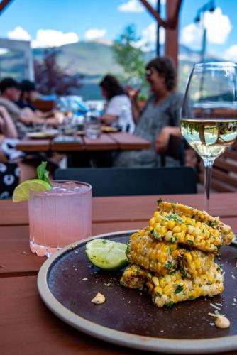 a plate of corn on the cob and a glass of wine at The Crimson Jasper in Jasper