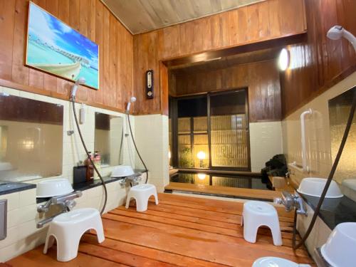 Hanamizuki Onsen Resort في إيتو: حمام مع مغسلتين ودورتين مياه