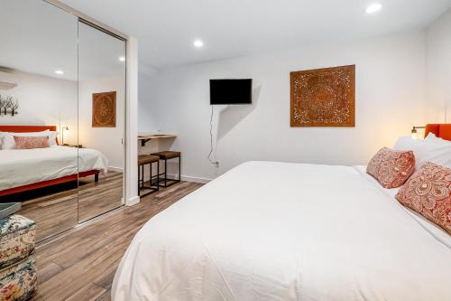 um quarto branco com uma cama e um espelho em Sweet Escape em San Diego