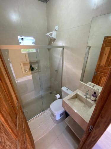 y baño con aseo, ducha y lavamanos. en Chalé Capão Vibes, en Vale do Capao