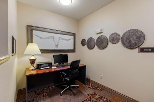 a room with a desk with a computer and a horse picture on the wall at Best Western Plus Red River Inn in Clarendon