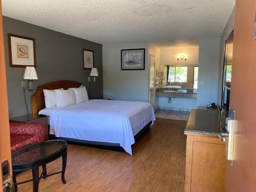 a hotel room with a bed and a living room at Howard Johnson by Wyndham Azusa in Azusa